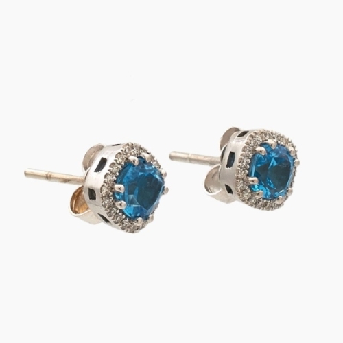 Pendientes cuadrados de oro blanco de 18k con un topacio azul central en talla de cojín y orla exterior de diamantes blancos. Pendientes cuadrados de oro blanco de 18k con un topacio azul central en talla de cojín y orla exterior de diamantes blancos.