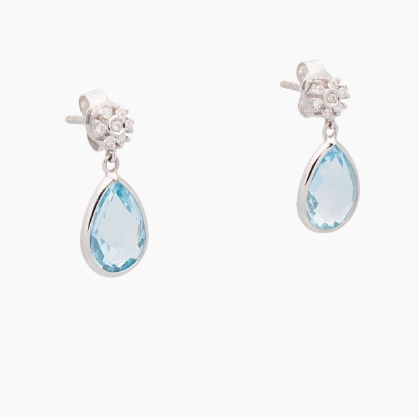 Pendientes largos de oro blanco de 18 kts con dos topacios azules en forma de gota y diamantes en la parte superior.