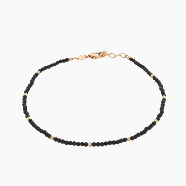 Pulsera de bolitas realizada en oro amarillo de primera ley y ónix natural. Cierre de mosquetón