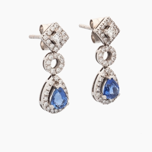 Pendientes largos realizados en oro blanco de primera ley, diamantes y zafiros. De diseño clásico y elegante, con dos zafiros de