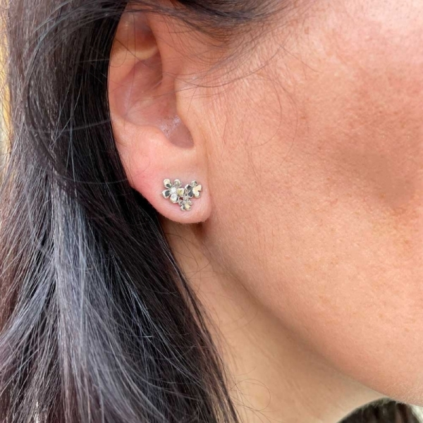 Pendientes con forma de tres flores realizados en oro blanco de primera ley y diamantes. Cierre de presión.