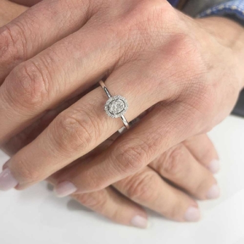 Solitario rosetón oval de oro blanco de primera ley y diamantes. Esta sortija de estilo vintage está compuesta por un centro cua