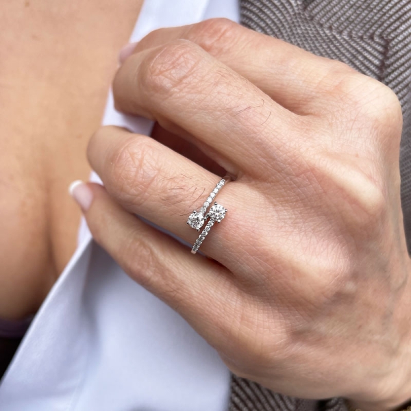 Sortija tú y yo con dos diamantes talla brillante en el centro y varios diamantes a los lados. En oro blanco de 18 ct