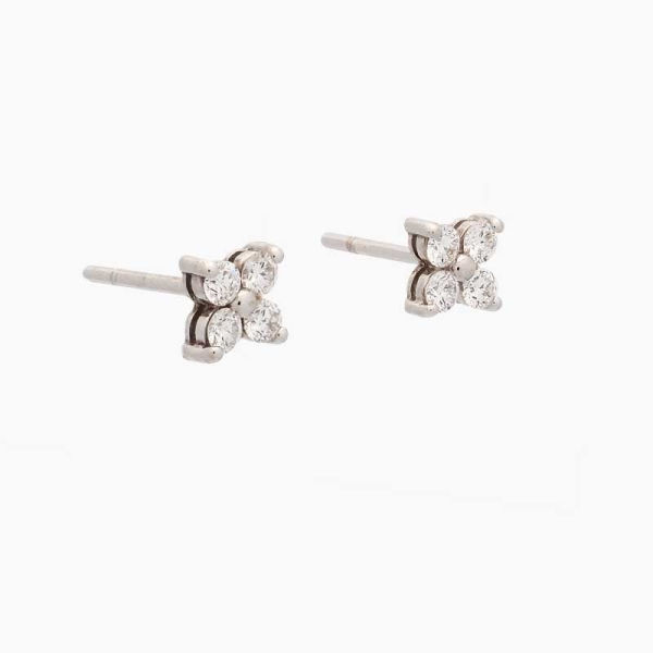 Pendientes con forma de flor, realizados en oro blanco de primera ley y cuatro diamantes en talla brillante. Cierre de presión.
