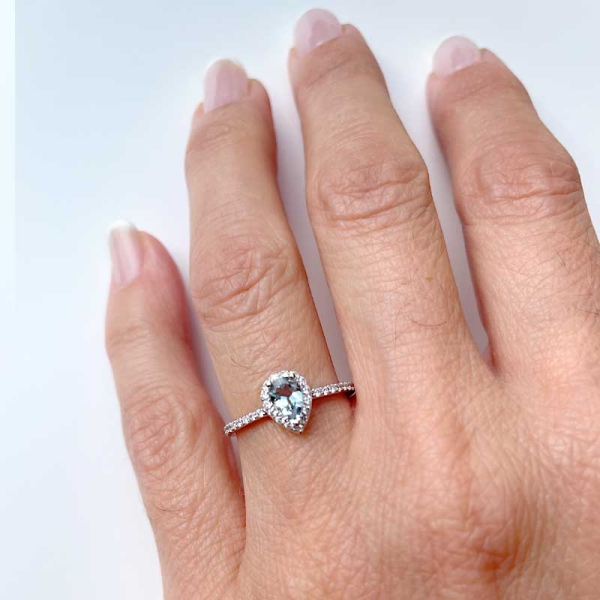 Sortija con aguamarina central en talla perilla rodeada de diamantes blancos. Realizada en oro blanco de primera ley