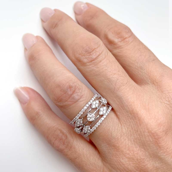 Sortija ancha con varios rosetones y dos hileras de diamantes, realizada en oro blanco de primera ley