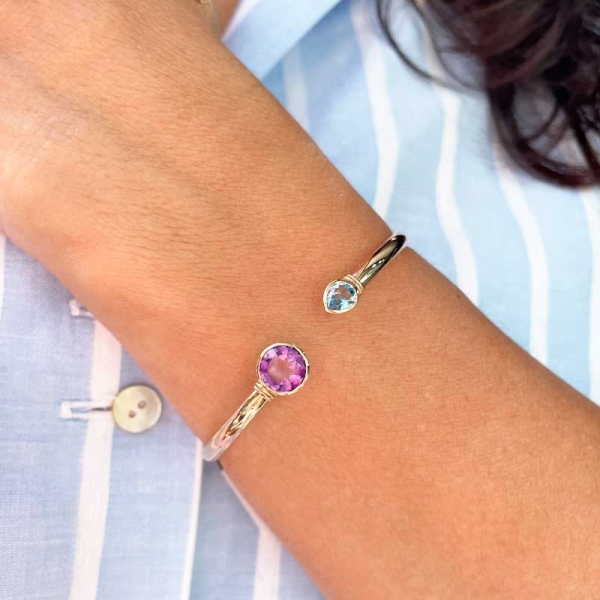 Pulsera rígida con un topacio azul en talla perilla y una amatista en talla brillante en oro rosa de primera ley.