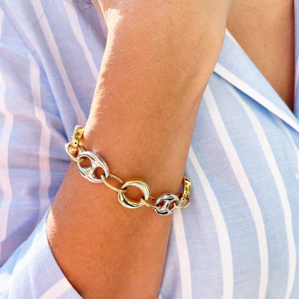 Pulsera combinada de calabrotes con eslabones ovalados en oro amarillo y blanco de primera ley. Cierre de mosquetón