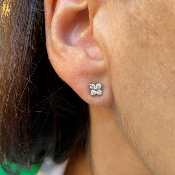 Pendientes con forma de flor, realizados en oro blanco de primera ley y cuatro diamantes en talla brillante. Cierre de presión.