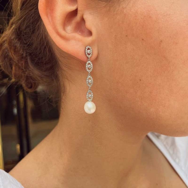 Pendientes de estilo romántico, de gran longitud realizados en oro blanco de primera ley, perlas cultivadas ovaladas y circonita