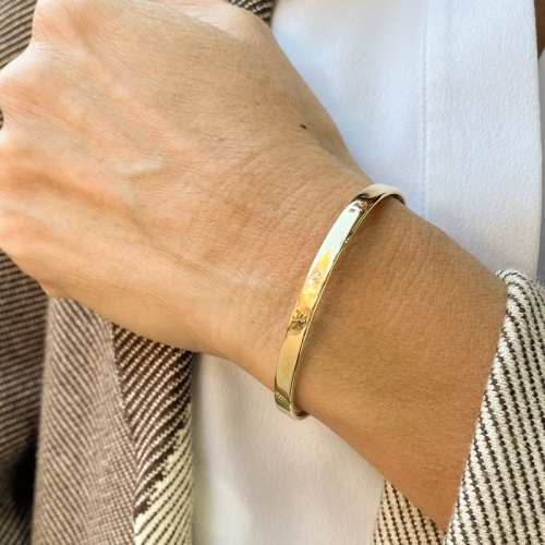 Pulsera rígida de forma plana con cadena y cierre de mosquetón, para mayor seguridad.
