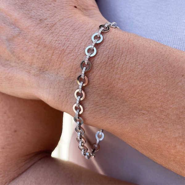 Pulsera de diseño moderno con círculos y barritas engastadas en circonitas. Realizada en oro blanco de primera ley. Cierre de mo