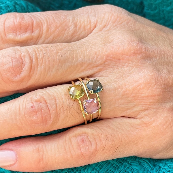 Sortija con una olivina natural tallada en forma cuadrada y engastada en garras, realizada en oro amarillo de primera ley